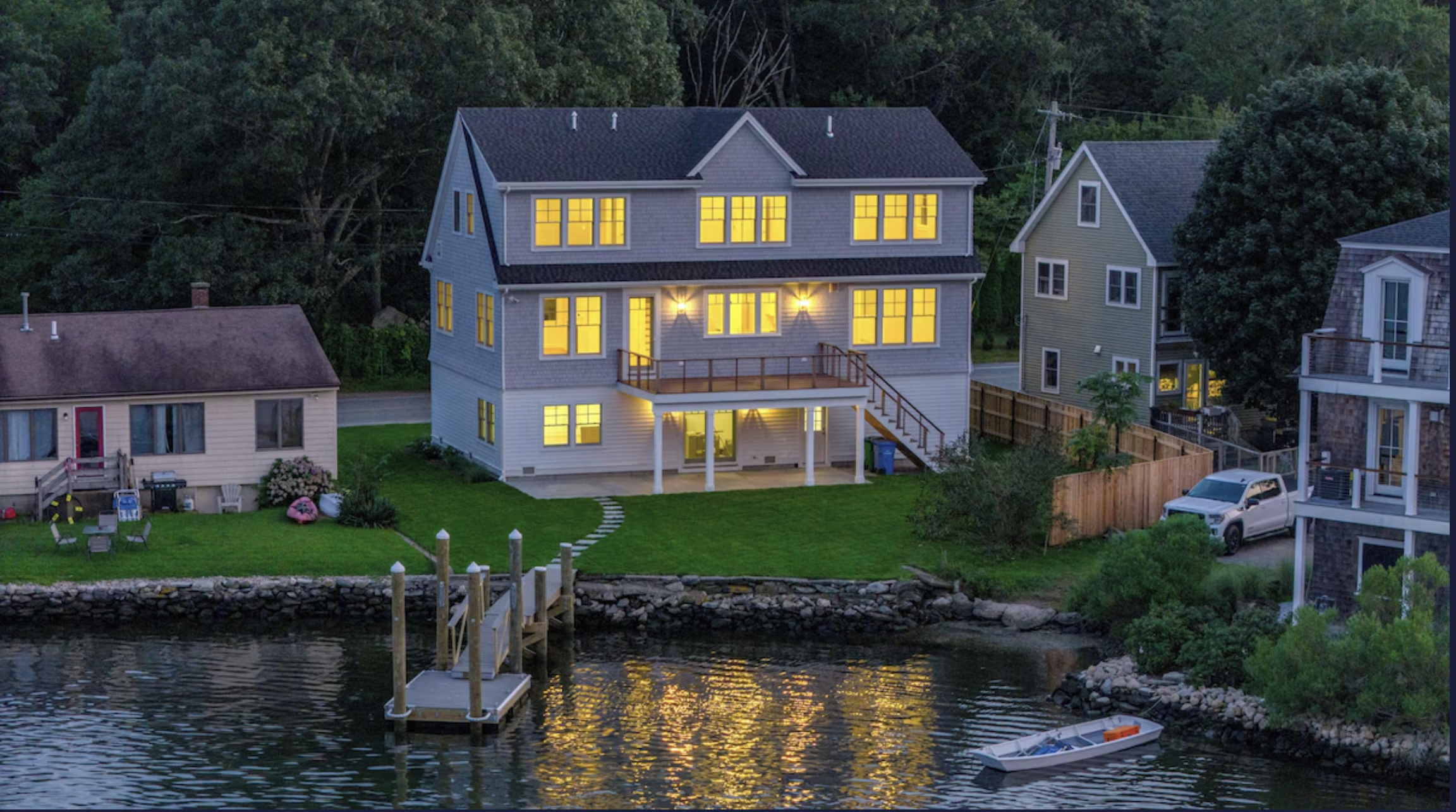 Waterfront home illuminated at dusk